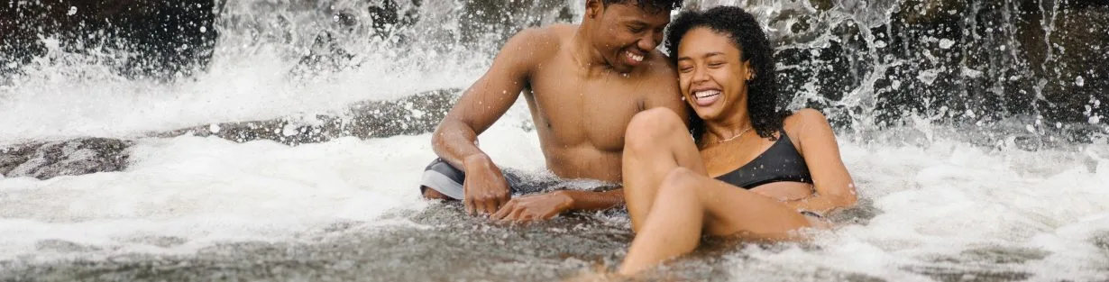 Couple souriant échangeant un regard complice lors d'une drague antillaise respectueuse.